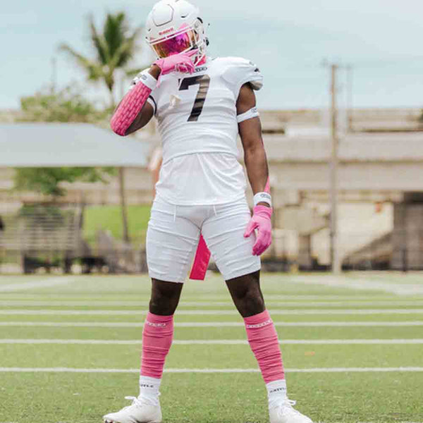 Football player wearing the Battle Adult Pink Long Sock Sleeves.